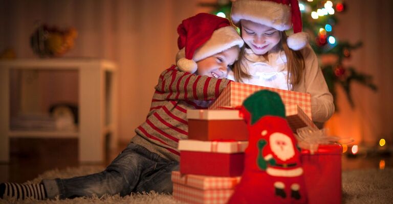 Dei bambini che scartano i regali di natale