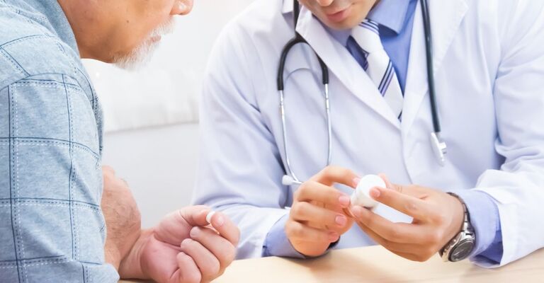 Un signore anziano parla con medico di una medicina