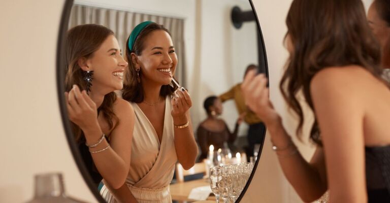 Due amiche che si truccano davanti allo specchio a Capodanno