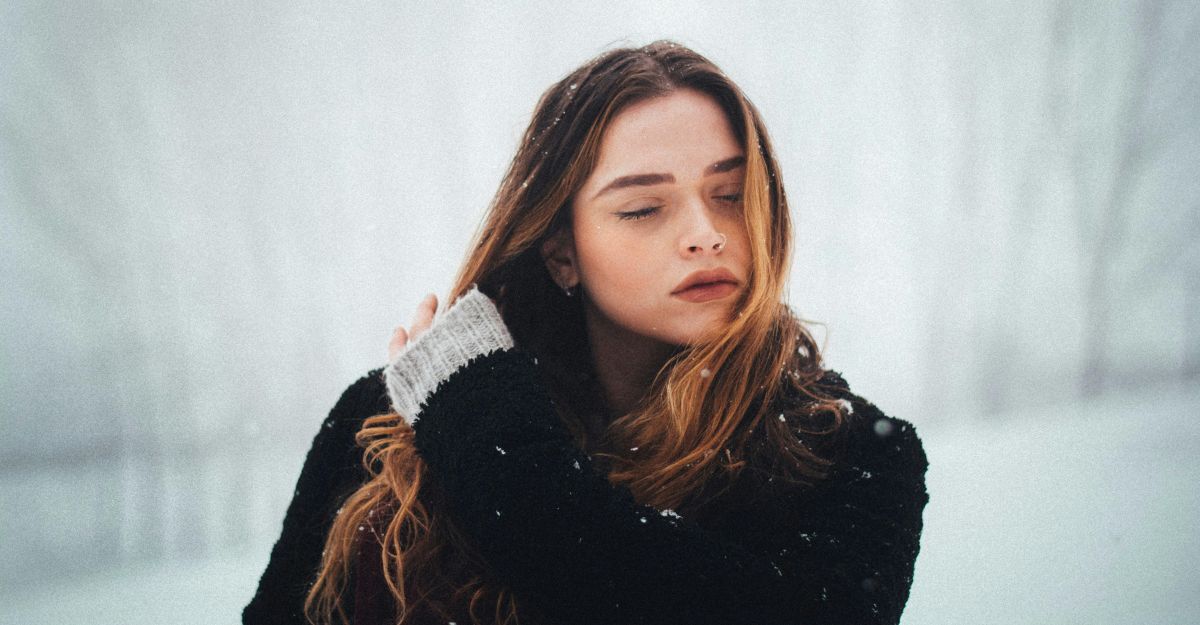 Ragazza sulla neve che si tocca i capelli