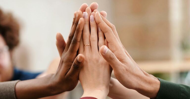 Persone uniscono le mani tutte insieme