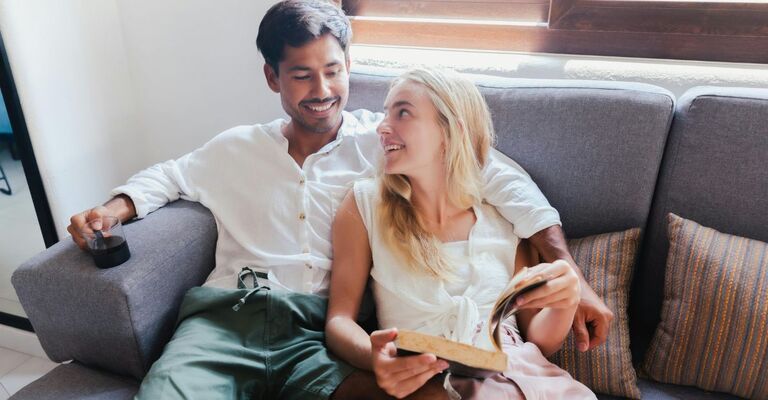 Una coppia sul divano che legge e si guarda