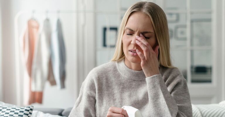Donna che si tocca l'occhio con la mano