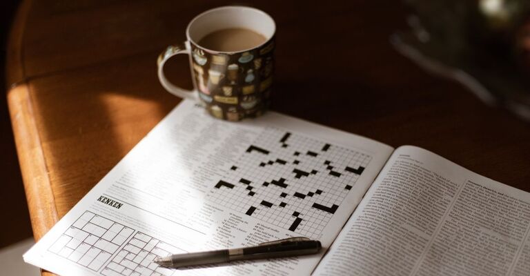 Tazza con caffellatte e cruciverba su un tavolo