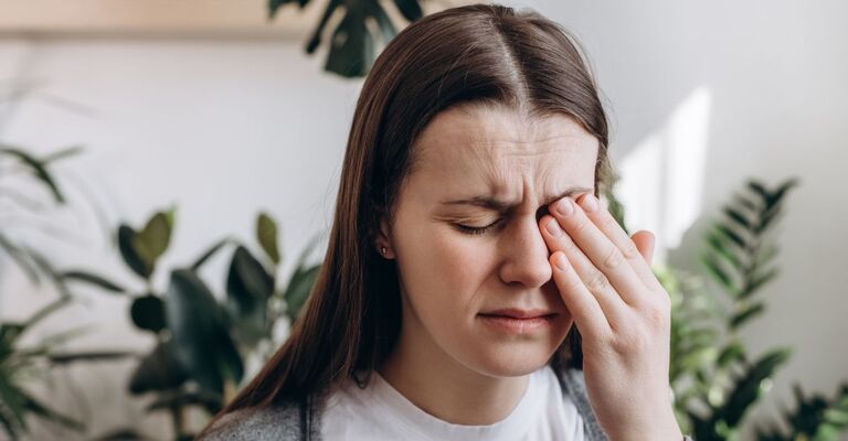 Ragazza che si copre l'occhio con una mano