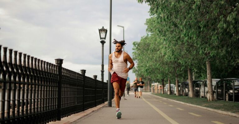 Ragazzo che corre in città su una pista apposita