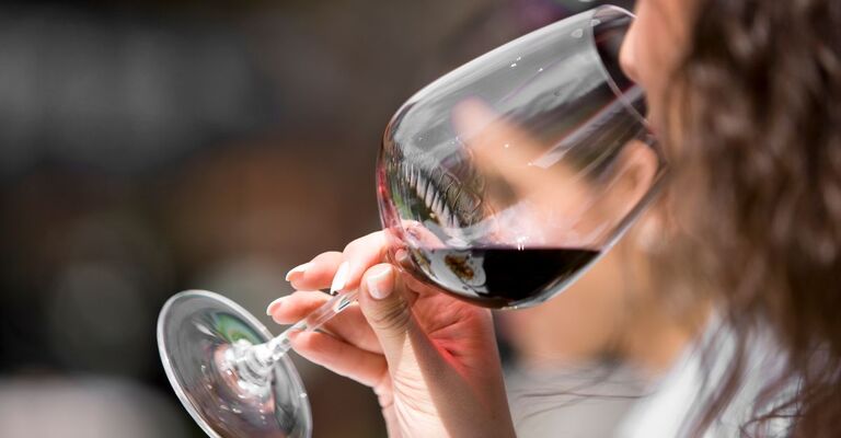 ragazza beve calice di vino rosso