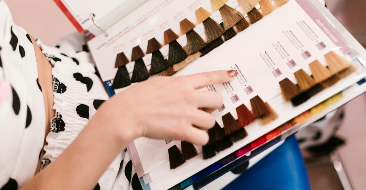 Primo piano su mani che indicano dei colori in un libro con le tinte