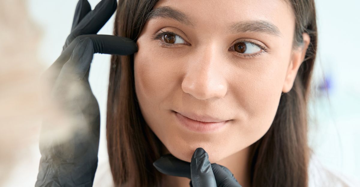 Una ragazza si fa controllare il viso da un dermatologo