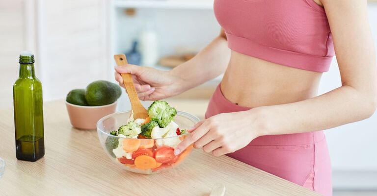 persona vestita sportiva si fa l'insalata