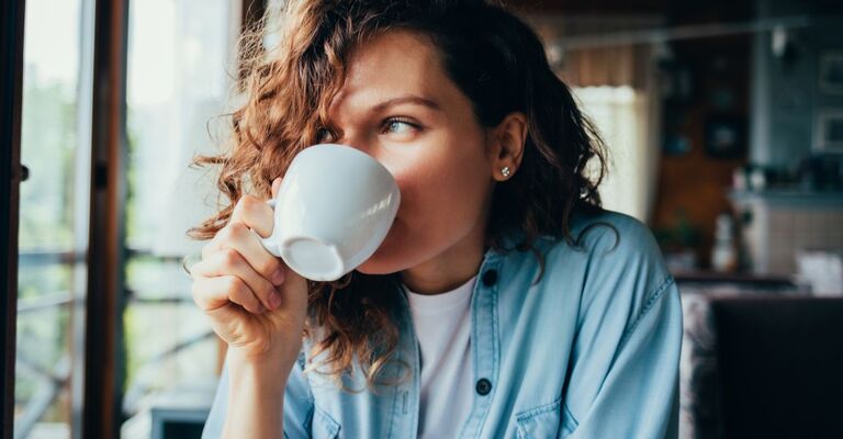 Una donna che beve caffè al bar