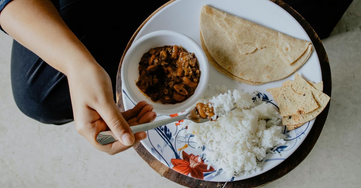 Persona che mangia riso in un piatto con condimenti asiatici