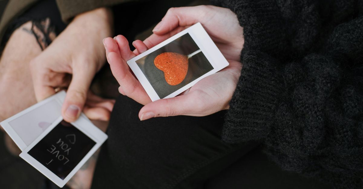 Mani che tengono in mano polaroid a tema San Valentino