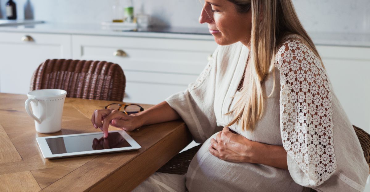 Una donna incinta seduta in salotto