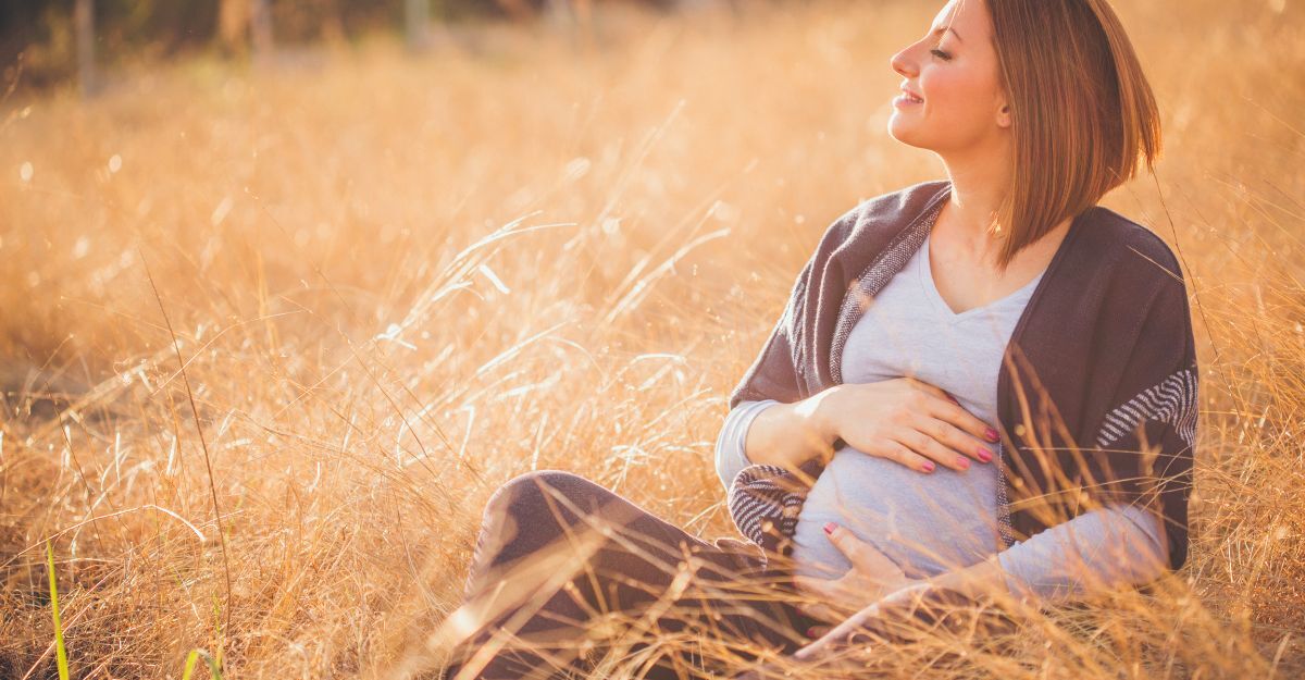 Una donna incinta seduta in un campo