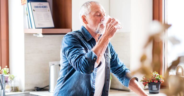 uomo beve un bicchiere d'acqua