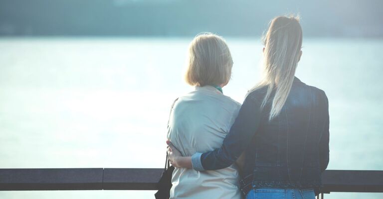 Una donna con una signora anziana guardano l'orizzonte di spalle