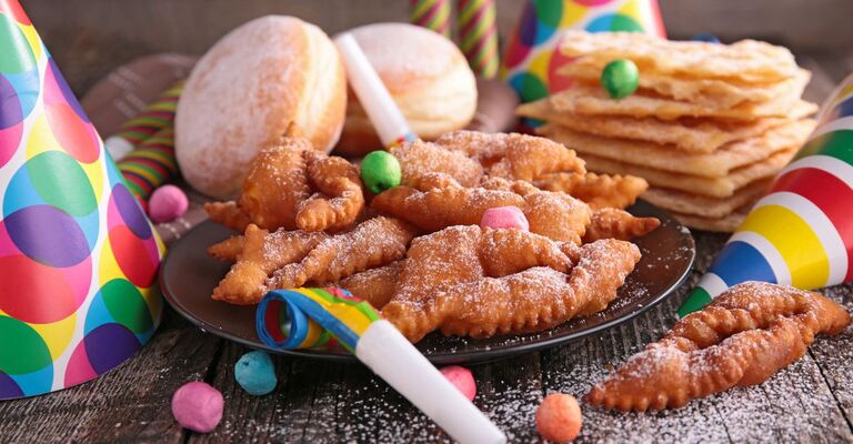 Varie tipologia di dolci di Carnevale con intorno decorazioni a tema