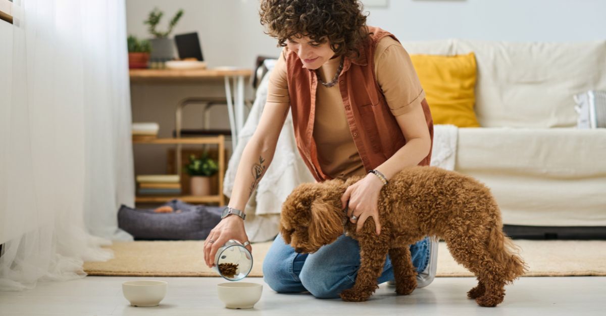 Ragazza che versa il cibo nella ciotola del suo cane che sta per mangiare