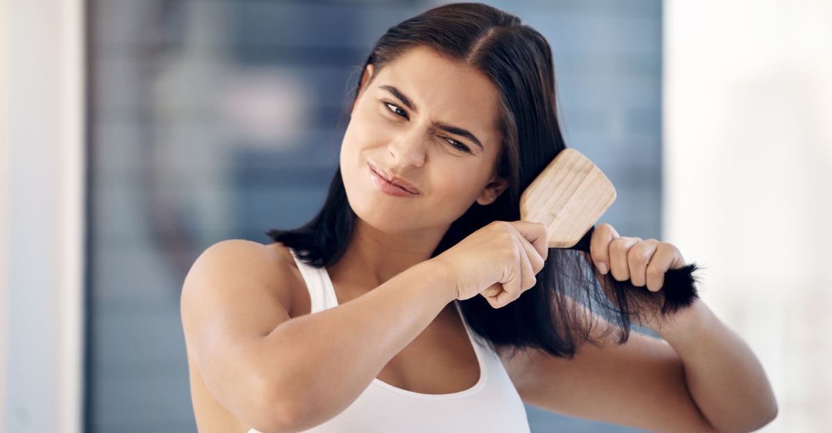 Una ragazza cerca di districare i nodi ai capelli con un pettine