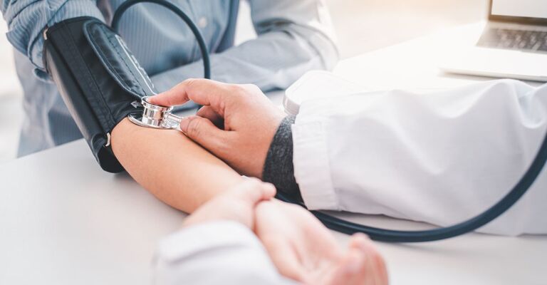 Un medico misura la pressione di un paziente