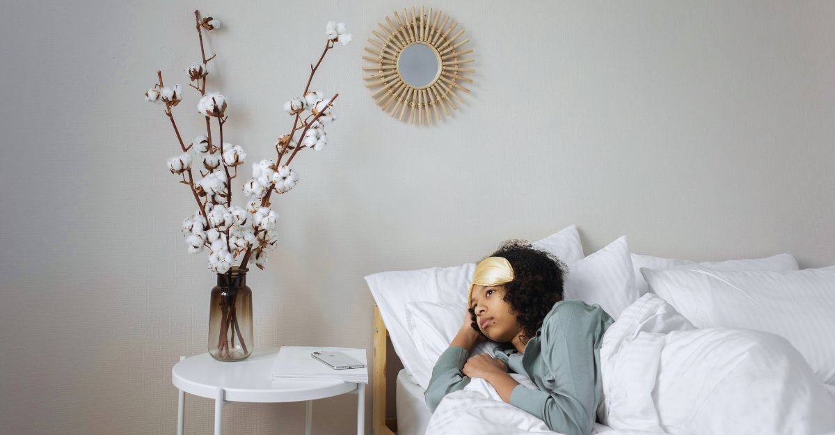 Donna sdraiata nel letto che guarda fuori sconsolata perché non vuole alzarsi