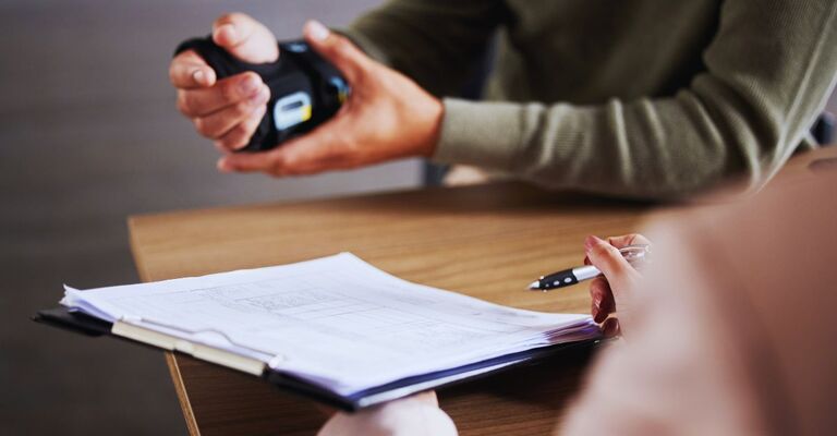 Persona con frattura al polso che valuta dei documenti in un ufficio prima di firmare