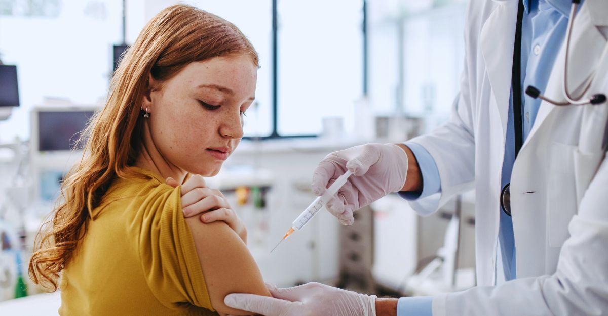 Medico somministra vaccino al braccio di una giovane ragazza coi capelli rossi
