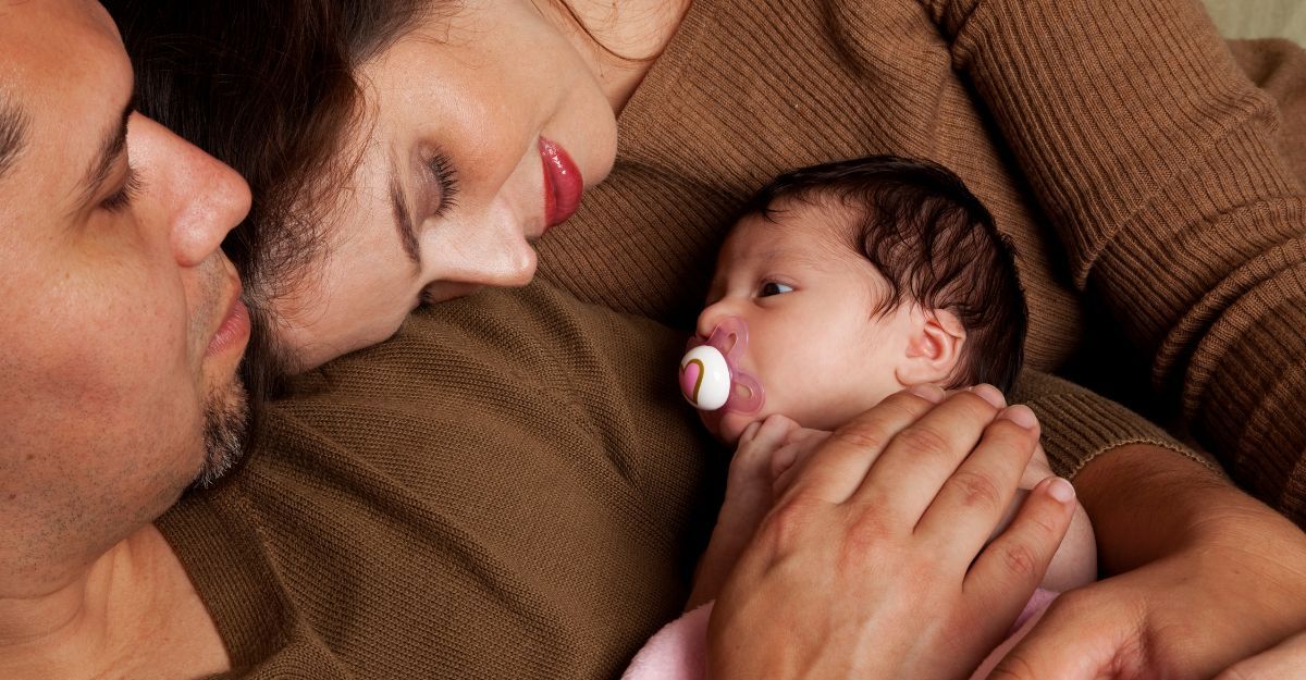 Un neonato in braccio al padre e alla madre