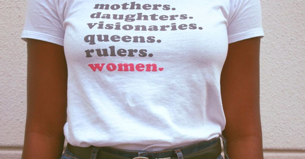 Donna nera con maglietta sulle donne bianca con delle scritte