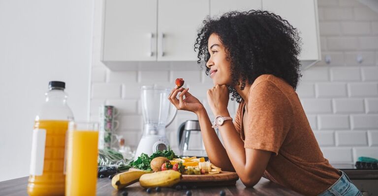 Una ragazza seduta al tavolo della cucina a mangiare