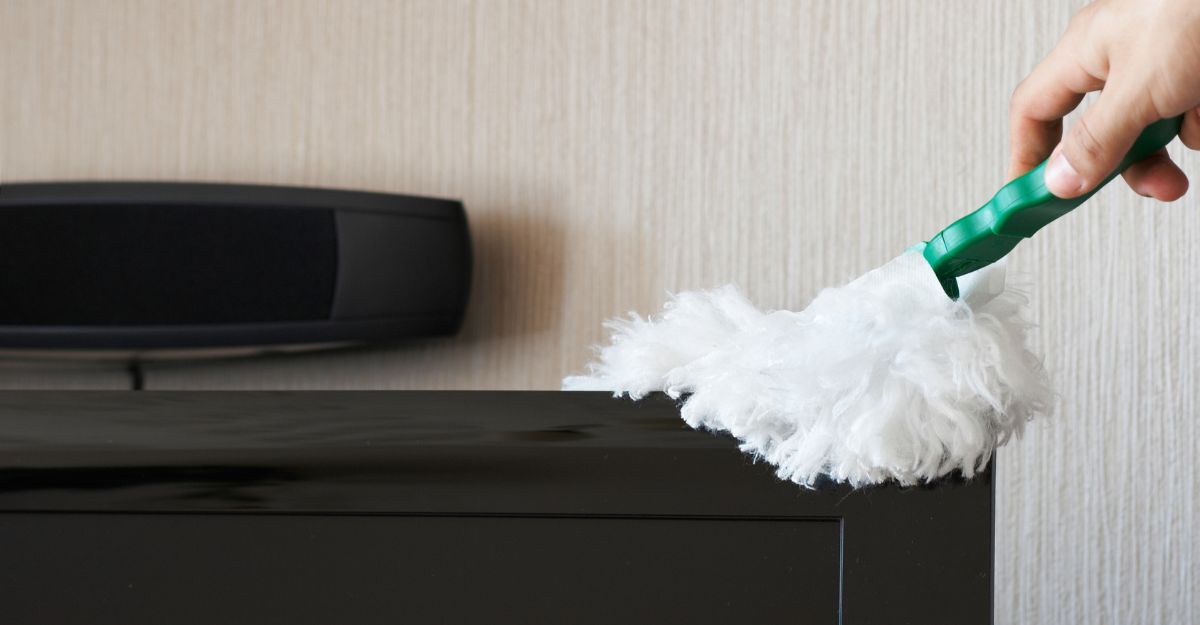 Una persona passa un panno in microfibra su un mobile per pulirlo dalla polvere