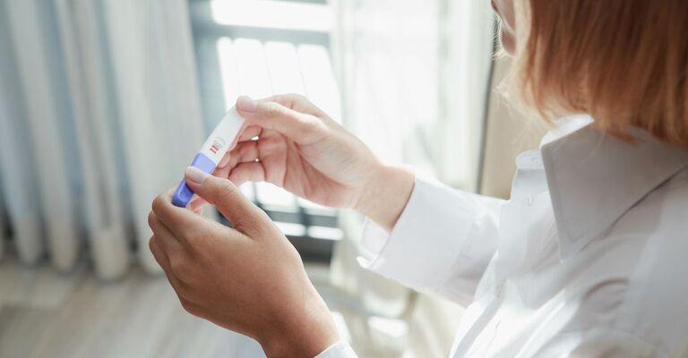 Una donna tiene in mano un test di gravidanza