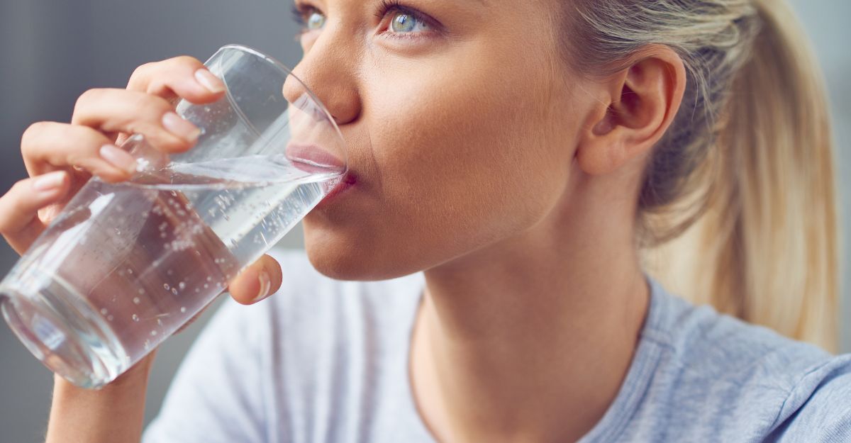 Una ragazza che beve un bicchiere d'acqua