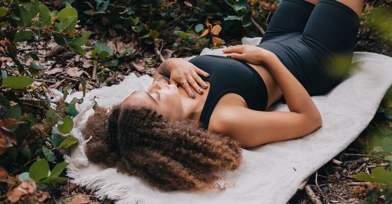 ragazza fa body scan sdraiata in un bosco