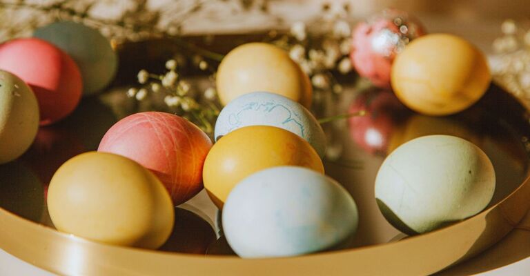 Uova colorate con colori pastello su un vassoio dorato per la Pasqua