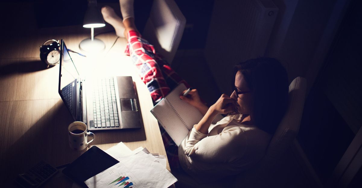 Una ragazza sveglia di notte che legge e guarda il computer