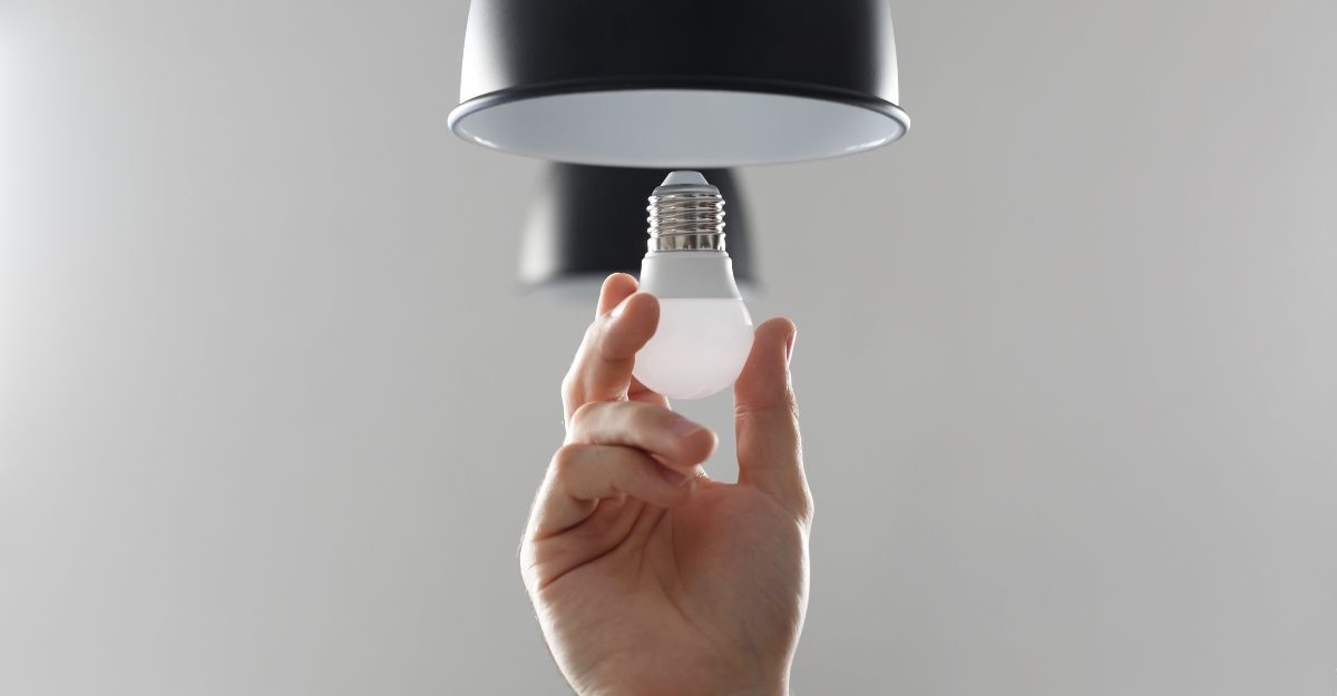 Una persona che cambia una lampadina