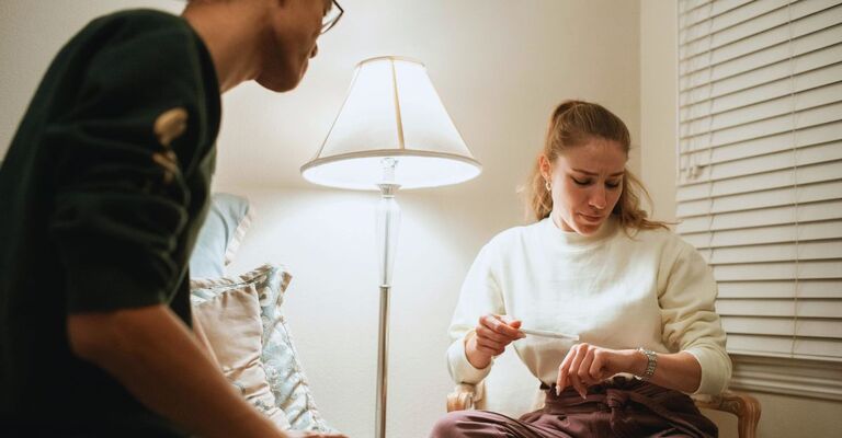 Ragazza seduta sulla sedia che aspetta l'esito del test di gravidanza