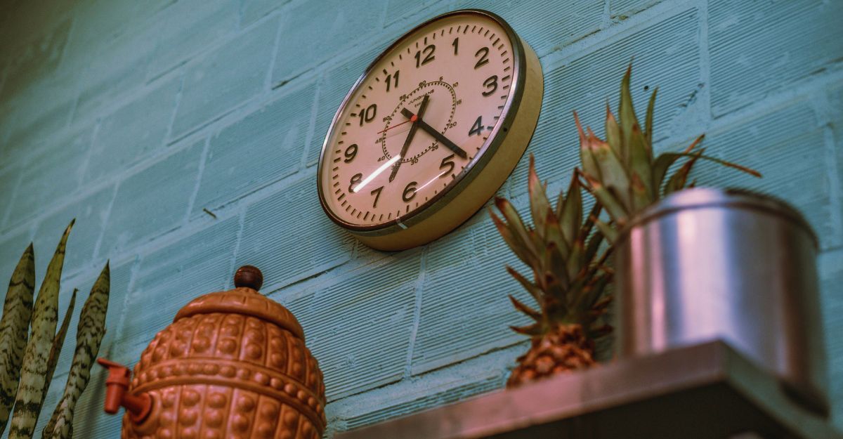 Orologio su una parte con mattonelle colorate e piante intorno