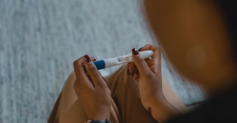 Una donna che tiene in mano un test di gravidanza