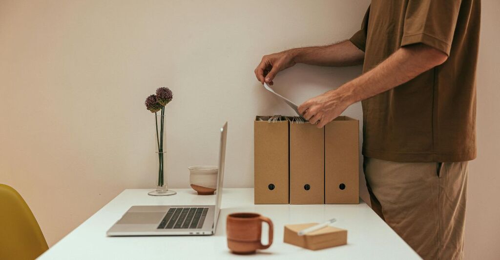 Ragazzo che riordina la scrivania e i documenti