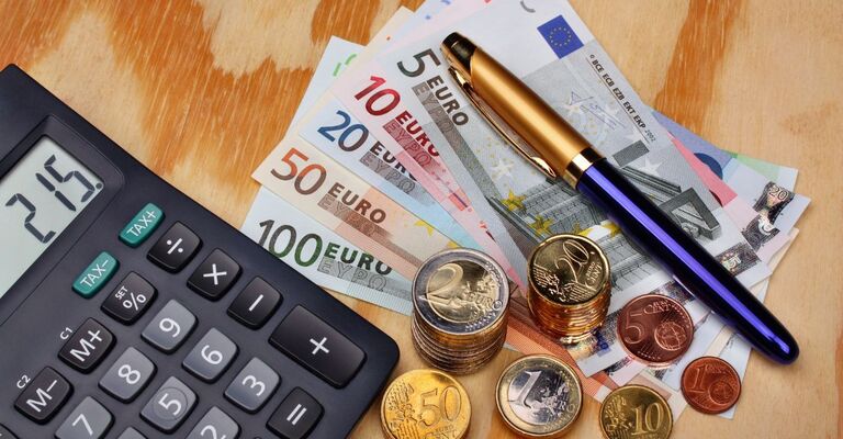 soldi in moneta, banconote, calcolatrice e penna