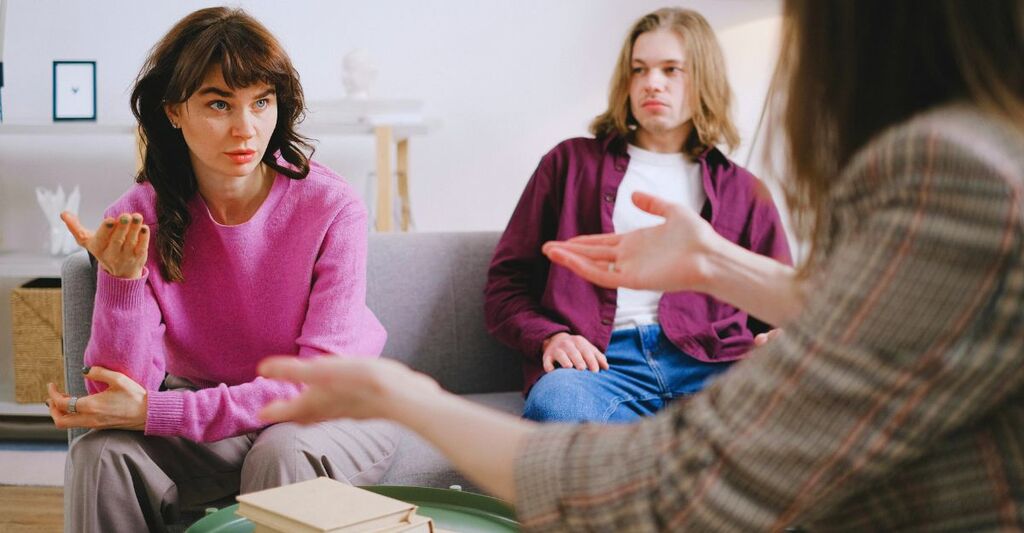 Primo piano di due persone in terapia che si confrontano con la terapeuta