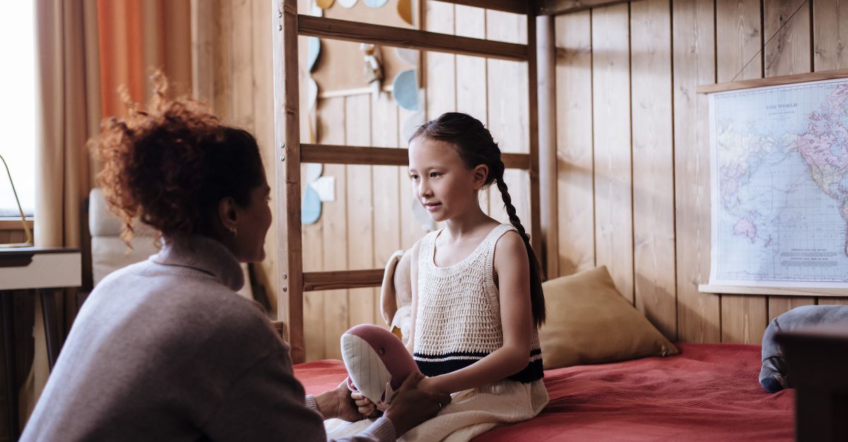 Una madre parla con la figlia seduta sul letto