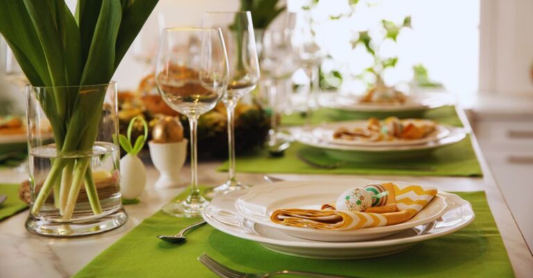 Tavolata di Pasqua con piatti e pietenze e sui toni del verde