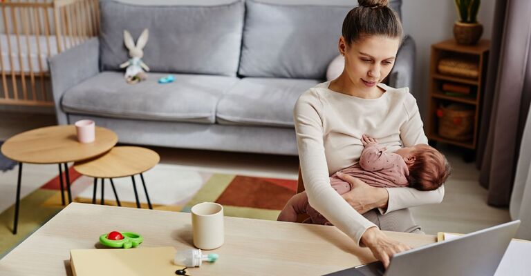 mamma lavora al pc e allatta bimba