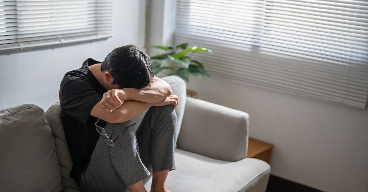 Un ragazza sopraffatto con la testa tra le gambe sul divano