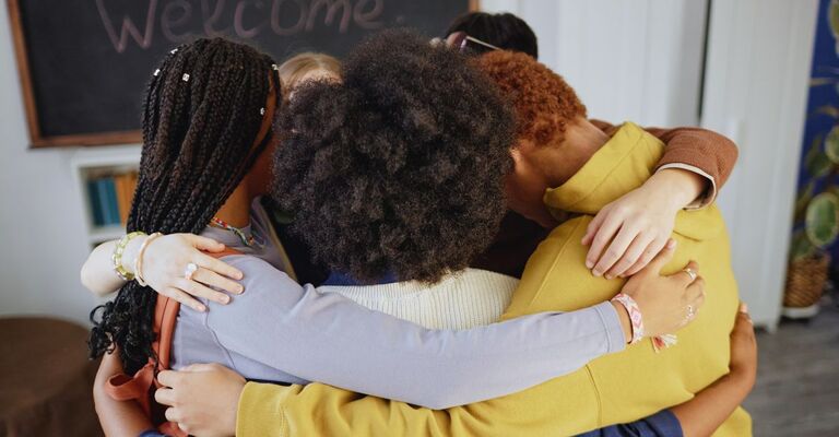 Gruppo di donne di varie etnie che si abbracciano