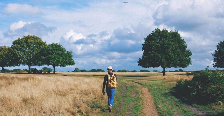 Paesaggio nella campagna con una persona con lo zaino che cammina